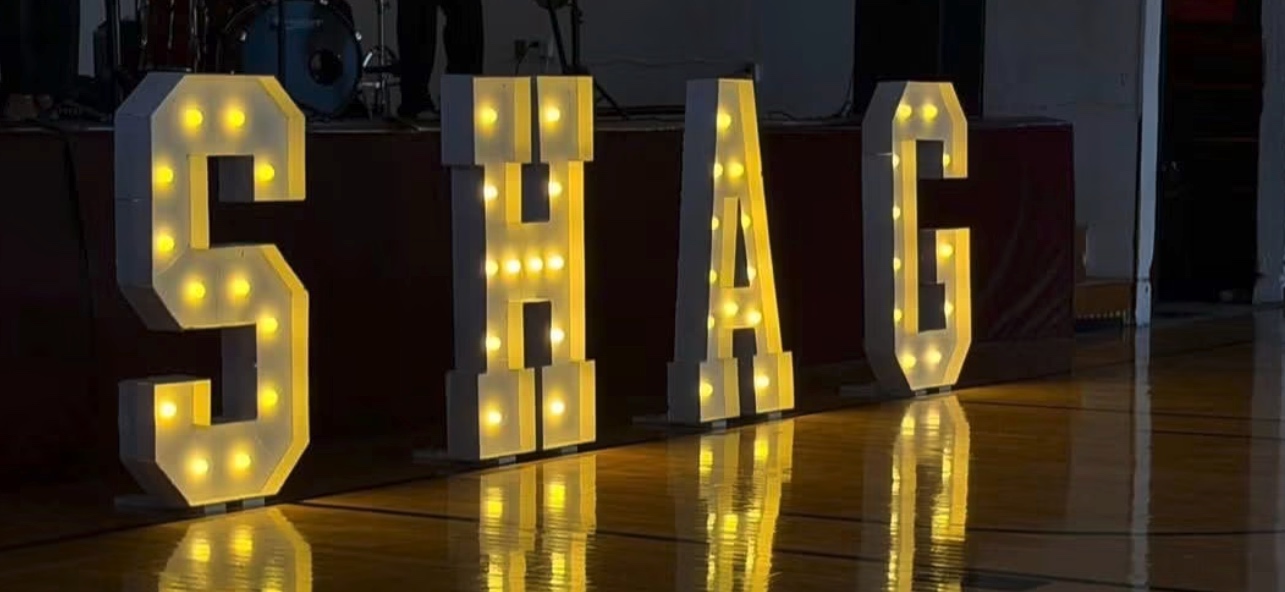 Illuminated marquee letters spelling SHAG on the dance floor at a Roanoke Valley Shag Club event